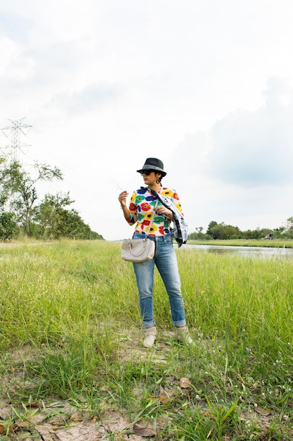 Thailändische Frau, die bunte Modekleidung trägt und Porträt für ein Foto im Freien in der Landschaft von Nonthaburi Thailand aufwirft