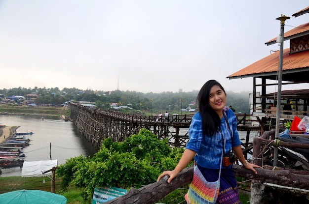 Thailändische Frauenreise und -porträt auf Holzbrücke Saphan Mon morgens in Sangkhlaburi am 4. Dezember 2015 in Kanchanaburi Thailand