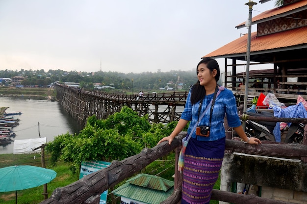 Thailändische Frauenreise und -porträt auf Holzbrücke Saphan Mon morgens in Sangkhlaburi am 4. Dezember 2015 in Kanchanaburi Thailand