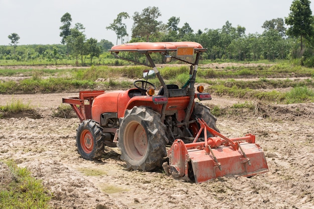 Thailändische Landwirte bereiten mit einem Traktor den Boden für den Reisanbau vor.