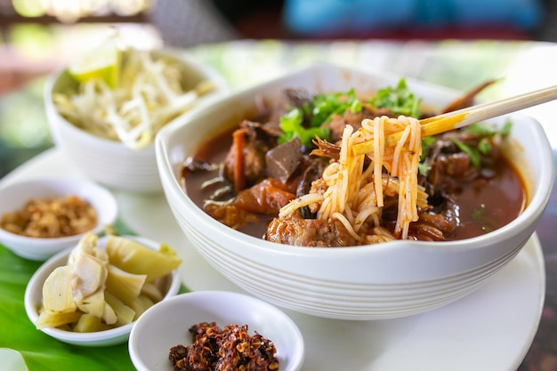 Thailändische Reisnudeln mit (nördlichem) Lanna-Curry namens Nam Ngio. Thai Essen.