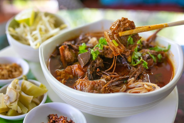 Thailändische Reisnudeln mit (nördlichem) Lanna-Curry namens Nam Ngio. Thai Essen.