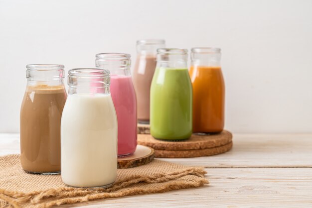 Thailändischer Milchtee, Matcha-Grüntee-Latte, Kaffee, Schokoladenmilch, rosa Milch und frische Milch in der Flasche