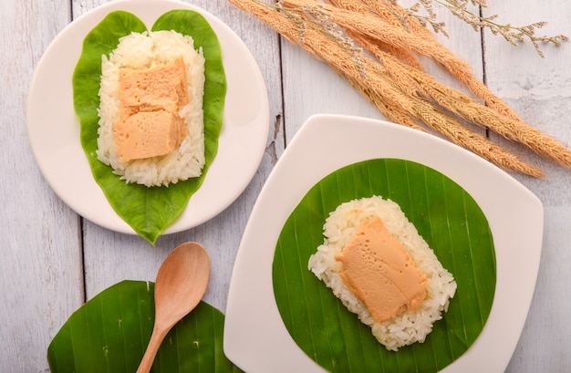 Thailändischer Nachtischei Vanillepudding mit klebrigem Reis auf Bananenblatt