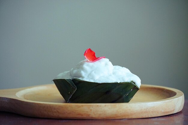 Foto thailändischer pudding mit kokosnuss auf einer holzplatte