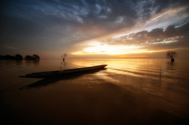 Foto thailändisches boot des langen schwanzes und schöner sonnenaufgang in dem meer am morgen.