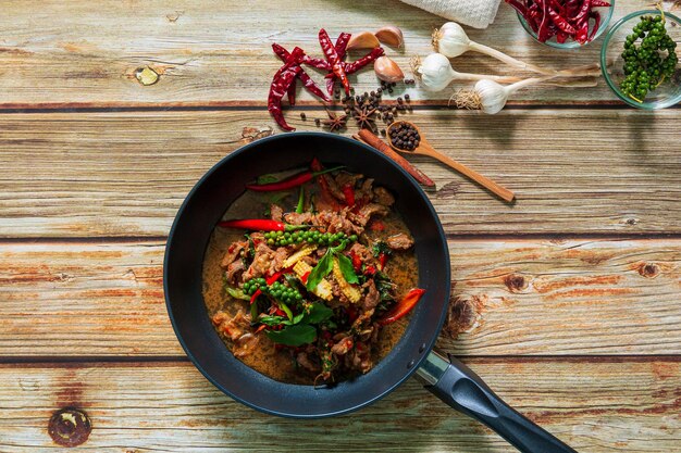 Thailändisches Rindfleisch mit Pfeffer und Basilikum auf Teller auf dunklem Steinhintergrund mit Kopierraum Top