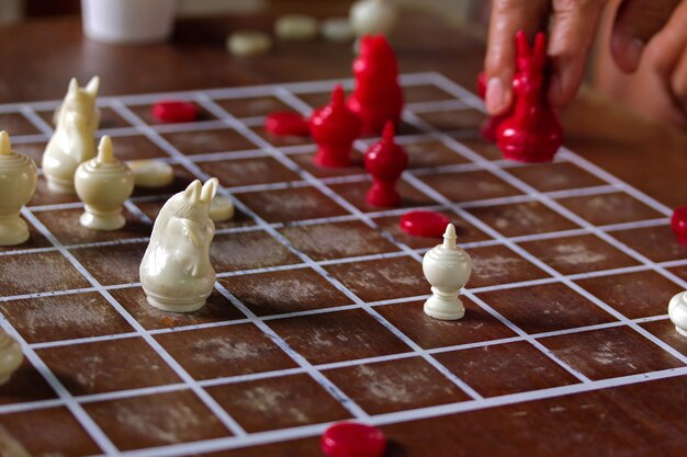 Thailändisches Schachrennen im Park. Schach hat Rot und Weiß auf hölzernem Schachbrett. Brainspiele, Hallensport