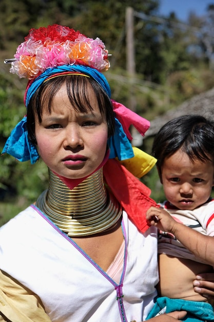 Thailand, Chang Mai, Karen Long Neck Hill Tribe Village (Kayan Lahwi), Long Neck Kind und ihre Mutter in traditionellen Kostümen. Frauen legen sich ab dem 5. oder 6. Lebensjahr Messingringe um den Hals