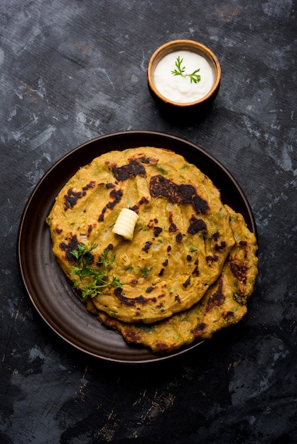 Thalipeeth es un tipo de panqueque sabroso de múltiples granos popular en Maharashtra, India, servido con cuajada, mantequilla o ghee