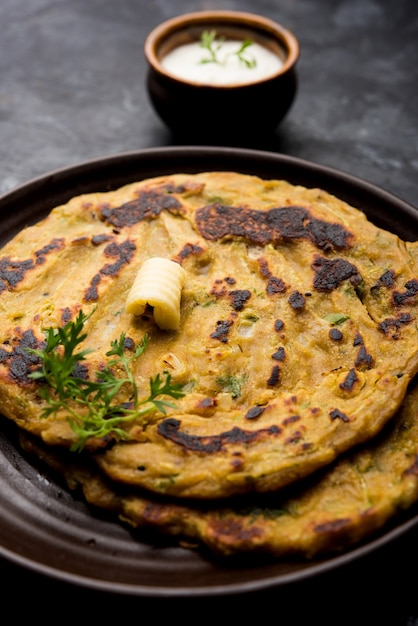 Thalipeeth es un tipo de panqueque sabroso de múltiples granos popular en Maharashtra, India, servido con cuajada, mantequilla o ghee