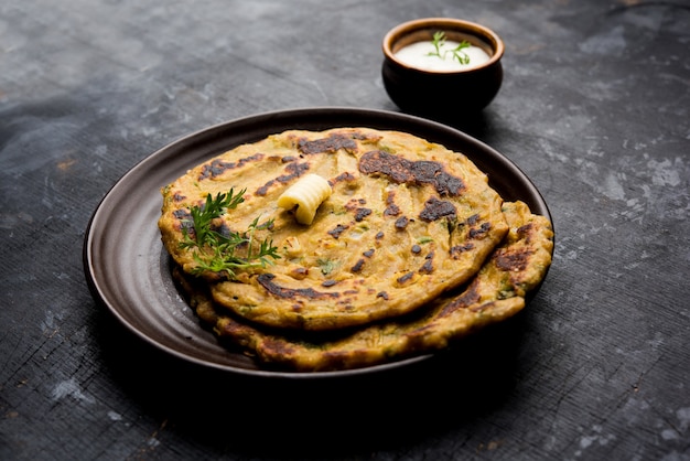 Thalipeeth es un tipo de panqueque sabroso de múltiples granos popular en Maharashtra, India, servido con cuajada, mantequilla o ghee