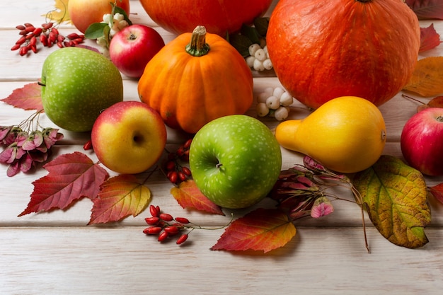 Thanksgiving-Dekor mit Kürbissen orange Kürbisbeeren Blätter rot-grüne Äpfel