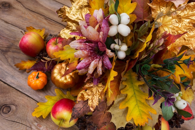 Foto thanksgiving-dekoration mit seidenblumen, schneebeeren und herbstlaub