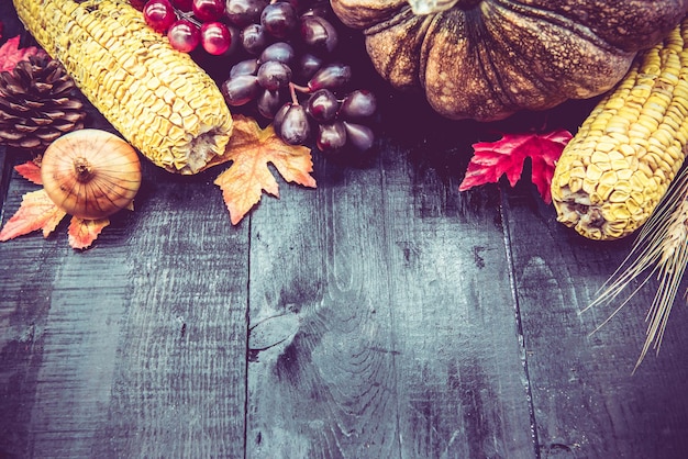 Thanksgiving-hintergrund mit obst und gemüse auf holz in der herbstsaison. kopieren sie platz für text.