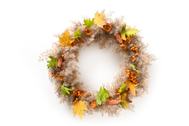 Thanksgiving-Kranz mit orangefarbenen Blüten und trockenen Naturmaterialien isoliert auf weiß