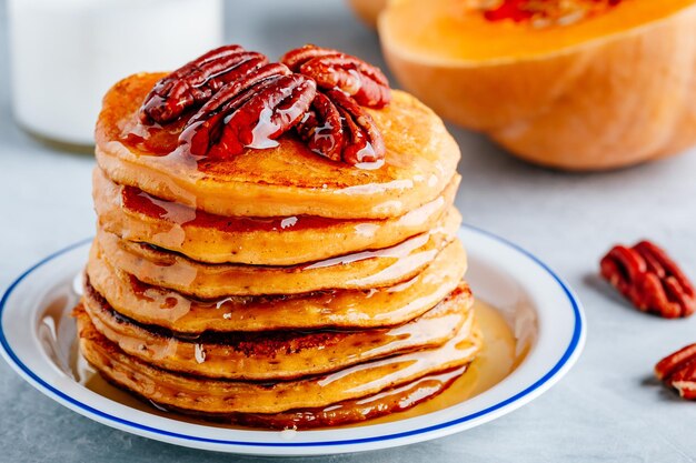 Thanksgiving-Kürbispfannkuchen mit Pekannüssen und Ahornsirup oder Honig