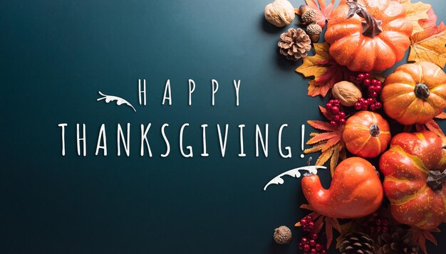 Thanksgiving- und Herbstdekorationskonzept aus Herbstblättern und Kürbis mit dem Text auf dunklem Hintergrund