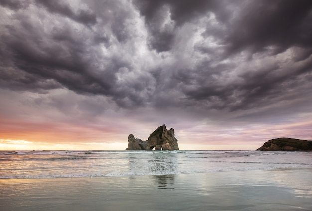 The archway islands of wharariki beach ao pôr do sol na nova zelândia