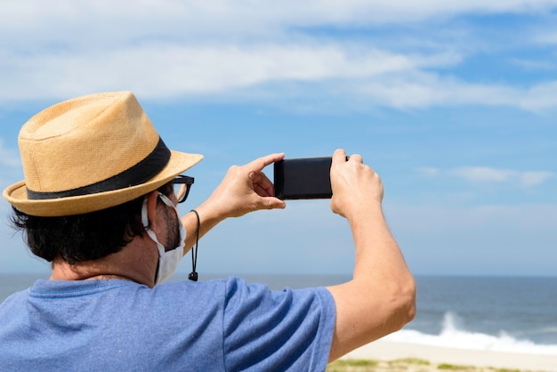 The new normal - hombre de mediana edad toma una foto de la playa