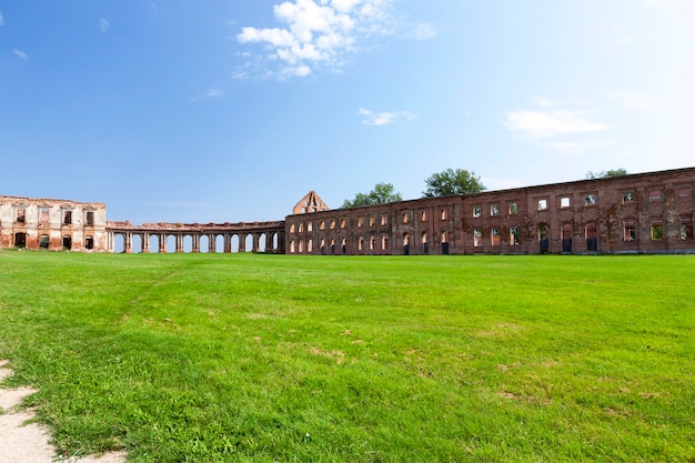 The ruinsimagem antiga fortaleza do século 16, situada na região da vila de ruzhany grodno, bielo-rússia, céu azul e grama verde no gramado