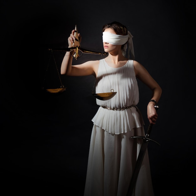 Themis, la diosa de la justicia, con los ojos vendados, con una balanza y una espada en sus manos, un juicio justo antiguo...