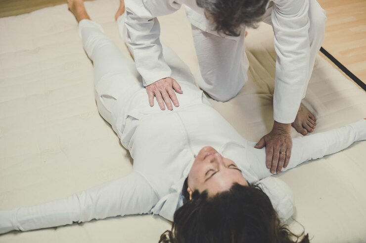 Foto therapeut, ein mann, der einer frau eine shiatsu-massage gibt, ganzheitliche therapiebehandlung mit manipulation
