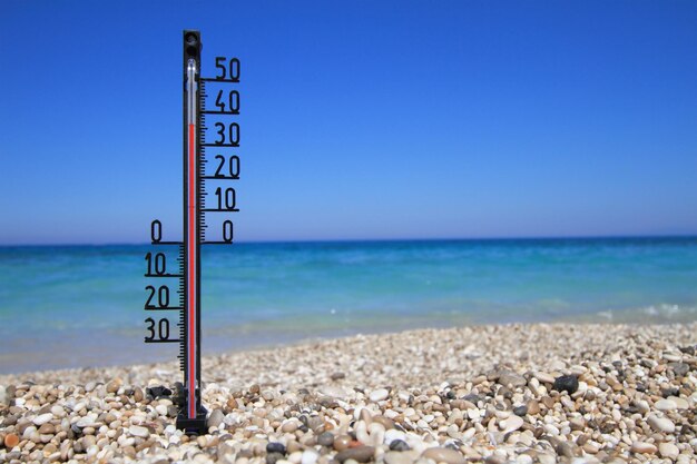 Thermometer an einem Strand zeigt hohe Temperaturen