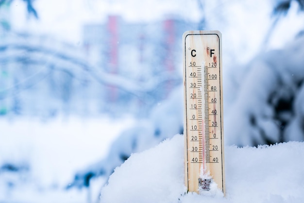 Thermometer auf Schnee mit niedrigen Temperaturen in Celsius oder Fahrenheit im Winter.