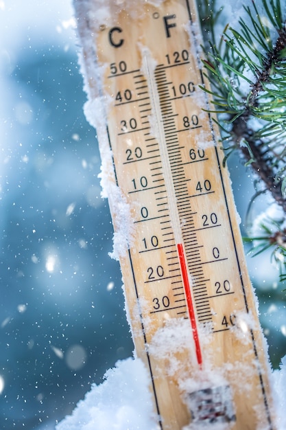 Thermometer auf Schnee zeigt niedrige Temperaturen in Celsius oder Fahrenheit an.