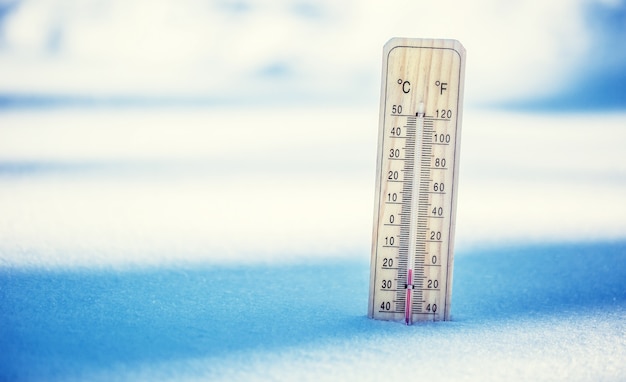 Thermometer auf Schnee zeigt niedrige Temperaturen Niedrige Temperaturen in Grad Celsius und Fahrenheit