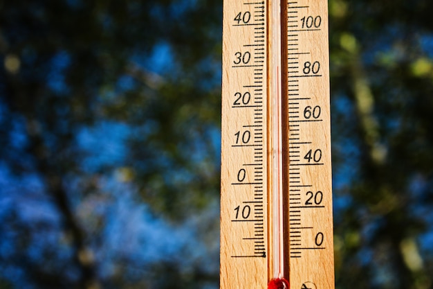 Thermometer, der am Sonnensommertag hohe 30 Grad heiße Temperaturen anzeigt.