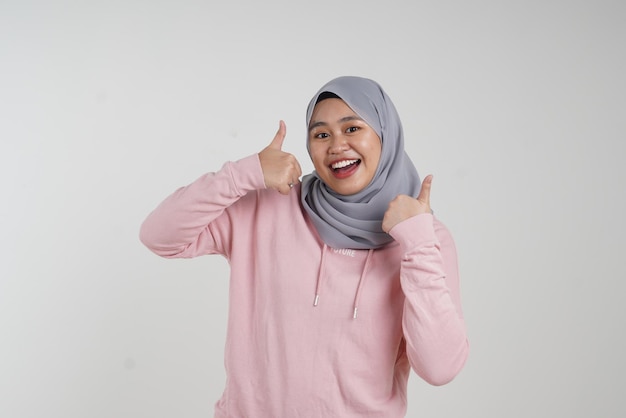 Foto thumbs up chica con móvil adolescente asiático malayo traje rosa casual
