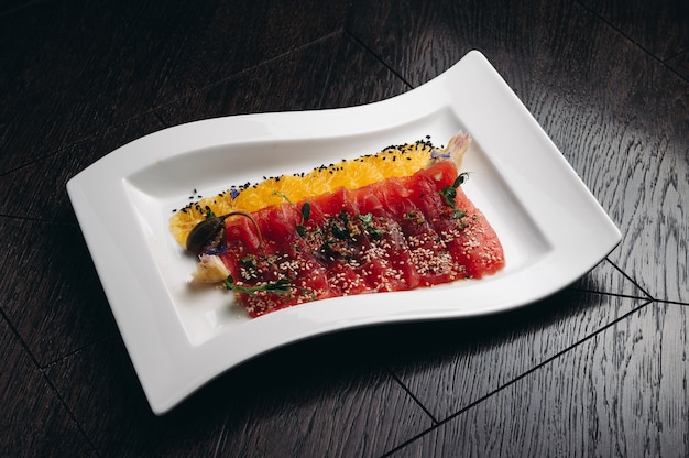 Thunfisch-Carpaccio mit Orange auf einem weißen Teller