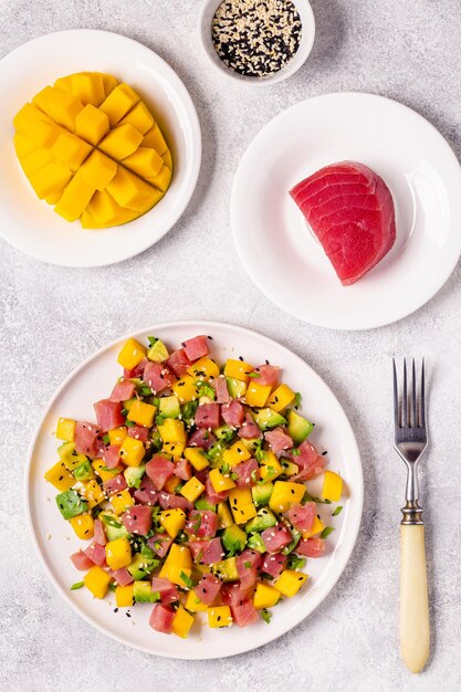 Thunfisch-Mango-Avocado-Salat-Tartar, serviert mit Frühlingszwiebeln und Sesamsamen