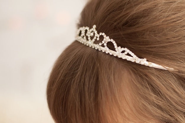 Foto tiara mit weißen steinen auf dem hellbraunen haar