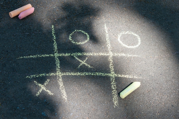 Tic-Tac-Toe-Kreidespiel auf Asphalt, Zeichnen auf dem Bürgersteig.