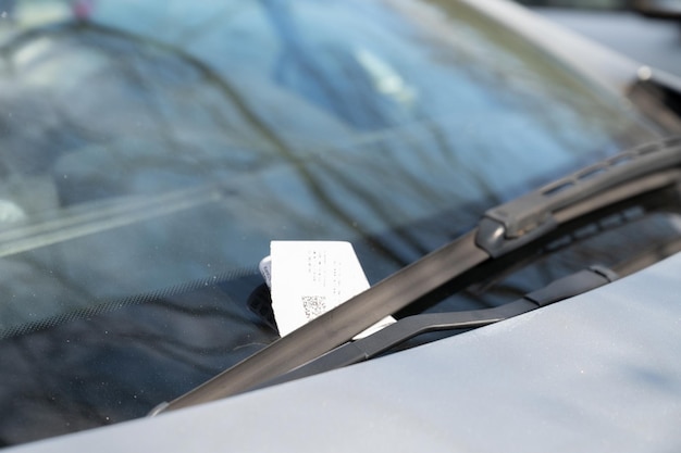 Ticket de estacionamiento bajo el limpiaparabrisas coche estacionado ilegalmente pagar violación de tráfico