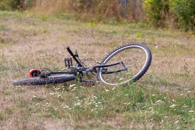 Ticycle, das auf dem Gras liegt. Sturz vom Fahrrad. Seien Sie vorsichtig beim Fahren_