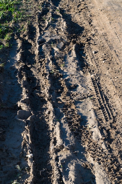 Tiefe Reifenspuren auf der Straße, die von nassem Schlamm bedeckt sind