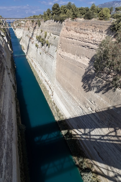 Tiefer schmaler Kanal durch den Fels geschnitten mit alter Brücke und Schatten der aktiven Brücke