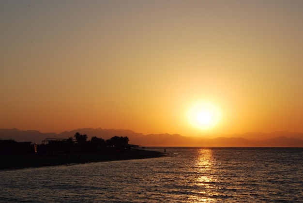 Tiefer warmer schöner Sonnenaufgang auf dem Meer und Feiertag