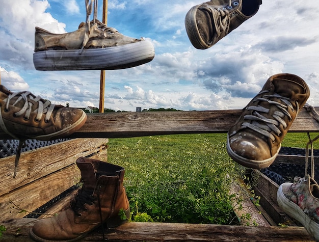 Foto tiefes abschnitt alter schuhe auf dem feld gegen den himmel