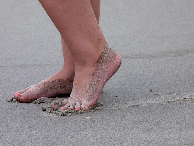 Foto tiefes bild von einer person, die am sandstrand steht