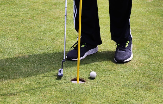 Tiefes Teil eines Mannes, der auf dem Spielfeld Golf spielt