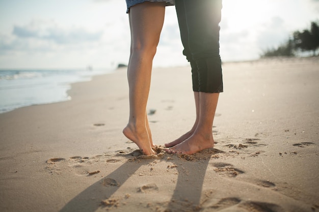 Tiefes Teil eines Paares, das am Strand steht