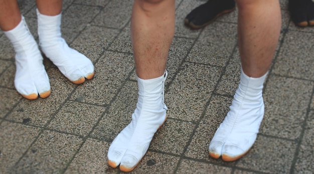 Tiefste Schicht von Leuten, die weiße Schuhe auf dem Fußweg tragen