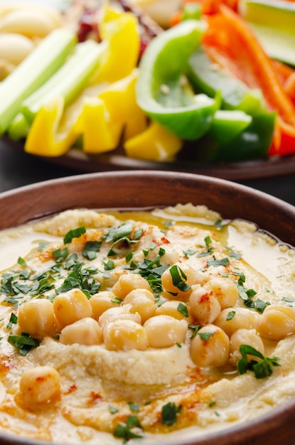 Tiefwinkelansicht auf Gemüse-Hummus-Dip-Teller mit Kichererbsen und Olivenöl