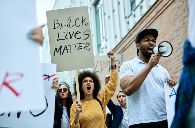 Tiefwinkelansicht einer multiethnischen Gruppe von Menschen, die auf öffentlichen Demonstrationen gegen Rassismus schreien