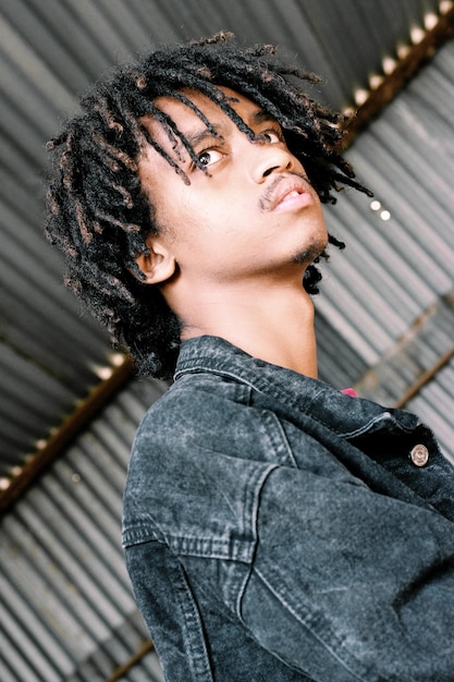 Tiefwinkelansicht eines nachdenklichen jungen Mannes mit Dreadlocks